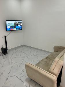a living room with a couch and a tv on a wall at T1 centro da cidade cif in Luanda