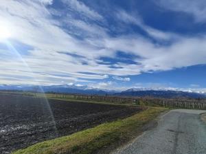 a dirt road next to a field with mountains at Corte Tegassa Pool & Spa in Pinerolo