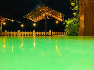 a swimming pool at night with a wooden fence at Nature Rock Ella in Ella