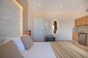 a bedroom with a large white bed and a kitchen at Petra Studios in Palaiochora