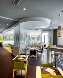 a restaurant with tables and chairs in a room at Rénéa Hotel in Sétif