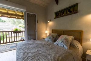 a bedroom with a bed and a balcony at L'étable des amis in Escalans +35 photos
