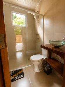 a bathroom with a toilet and a sink and a window at Canto Sereno Refúgio entre Praias e Ilhas in Paraty