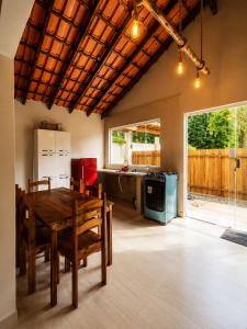 a kitchen with a wooden table and a dining room at Canto Sereno Refúgio entre Praias e Ilhas in Paraty