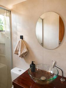 a bathroom with a glass bowl sink and a mirror at Canto Sereno Refúgio entre Praias e Ilhas in Paraty