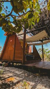 a tree house with a deck and a hammock at Glampiri in Pirenópolis