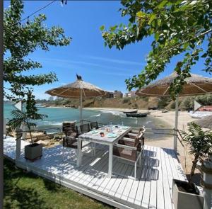 a table and chairs on a deck with the beach at AKT Residence in Agigea