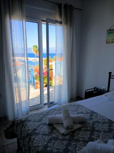a bedroom with a bed and a view of the ocean at ANGIRA - Koroni Apartments in Koroni