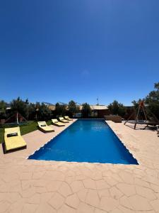 a swimming pool with lounge chairs in a resort at auberge Brava Tifnit in El Azib