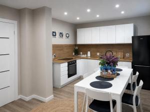 a kitchen with a white table and white cabinets at Helski Zakątek in Hel