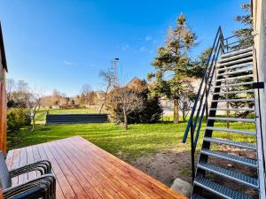 a porch with a wooden deck with stairs and a yard at Fewo im Taubenhaus in Bad Lausick