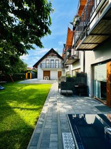 a house with a patio and a yard at Domki Apartamentowe 3Fale in Władysławowo