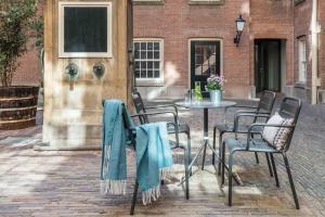 a patio table and chairs with blue towels on them at Wittenberg by Cove in Amsterdam
