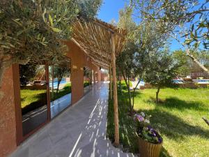 a garden with a pergola next to a building at auberge Brava Tifnit in El Azib