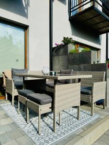 a dining table and chairs on a patio at Domki Apartamentowe 3Fale in Władysławowo