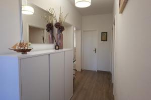 a hallway with white cabinets and a mirror at Apartment Jugo in Preko +12 photos