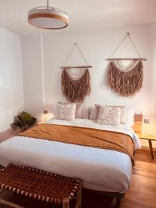 a bedroom with a large bed and two hanging baskets at Raíces de Canillas Holiday Apartments in Canillas de Aceituno