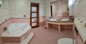 a pink bathroom with two sinks and a tub at Ubytovanie Kubik 473 in Liptovský Mikuláš +15 photos