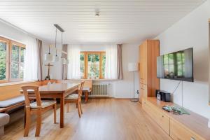 a dining room with a table and a tv at Ferienwohnung Bergfranzenhof in Oppenau