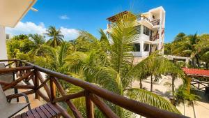 a balcony with palm trees and a building at Villas Palmar Holbox in Holbox Island