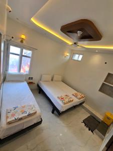 a bedroom with two beds in a room at TEMPLE VIEW GUEST HOUSE in Hampi