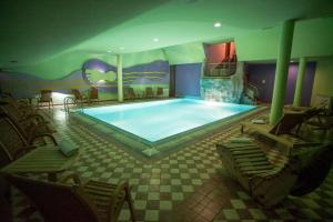 a large swimming pool in a room with chairs at Monti Wellness & Spa Vlašić in Vlasic +77 photos