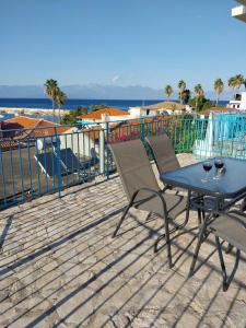 a patio with a table and chairs on a deck at ANGIRA - Koroni Apartments in Koroni