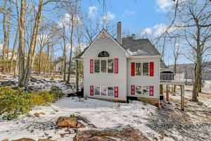 a white house with red shutters in the snow at Poconos Paradise Lakeskihikewater Parkkids in Lake Harmony