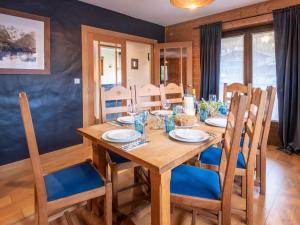 a wooden dining room table with blue chairs and a table and chairsktop at Chalet Bolay in Montriond