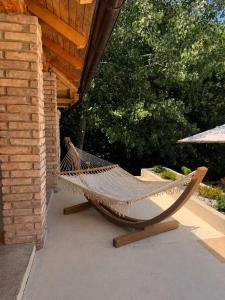 a hammock on a porch of a house at Villa Tri tačke in Debeljaci