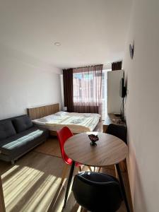 a small room with a bed and a table at Apart Hotel TRIBU Bakuriani in Bakuriani +2 photos