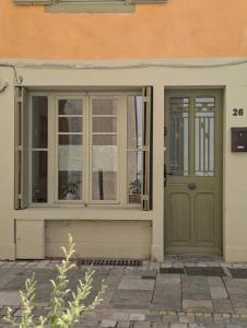 a house with a green door and windows at Les Chapeliers in Foix