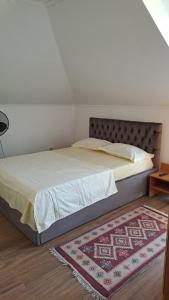 a bed in a bedroom with a rug on the floor at Casa Sara in Eforie Nord