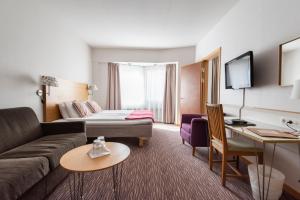 a hotel room with a couch and a bed at Mora Hotell & Spa in Mora