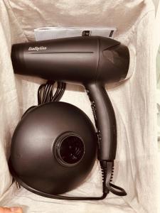 a hair dryer in a bag with a camera at Charmant studio proche gare - parking privatif individuel clos in Arras