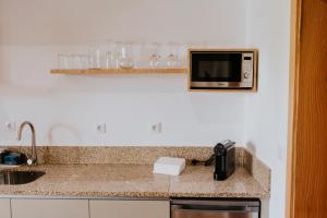 a kitchen counter with a sink and a microwave at Quinta do Codeçal in Vila Real +146 photos