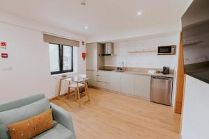 a living room with a couch and a kitchen at Quinta do Codeçal in Vila Real