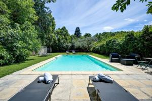a swimming pool with two chaise lounges next to at lemasrocamour in Roquemaure