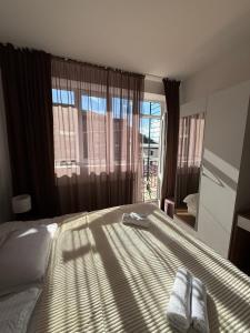 a bedroom with a bed with two towels on it at Apart Hotel TRIBU Bakuriani in Bakuriani