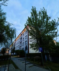 a large building with a tree in front of it at Apartament Harmony in Ełk