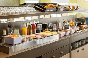 a buffet line with various foods and drinks at Appart'City Collection Nîmes Arènes in Nîmes