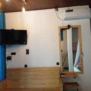 a room with a tv and a mirror at Rawana River Edge in Ella