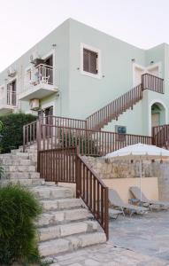 a staircase leading up to a house with an umbrella at Perla Apartments in Agia Pelagia