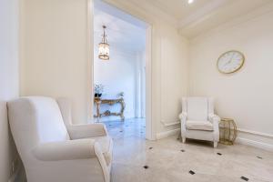 a living room with two chairs and a clock on the wall at Hotel Eden in Budva