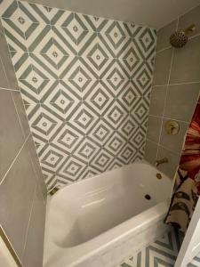 a white bath tub in a bathroom with a tile wall at Luv Happii House in Country Club Hills +38 photos