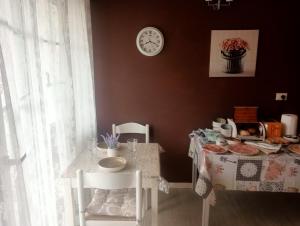 a dining room with a table and chairs and a clock at Villa Rosetta relax in Scrutto