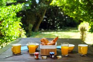 a table with a basket of bread and glasses of orange juice at lemasrocamour in Roquemaure