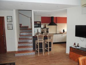 a kitchen and living room with a staircase with stools at Apartamento Les Fonts in Polop