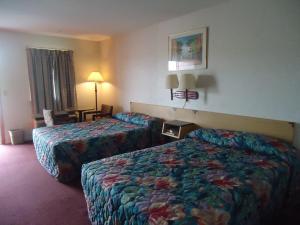 a hotel room with two beds and a table at Welborn Motel - Hamptonville in Hamptonville