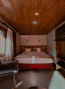 a bedroom with a large bed with a wooden ceiling at Hotel Cabanas Glamour in Gramado